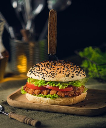 Grilled Chicken Burger at De Flambe, a top-rated restaurant in Blue Area, Elysium Tower, Islamabad. Famous for its best grilled chicken burgers, served in a soft bun with fresh toppings and flavorful sauces.