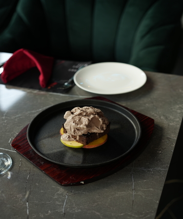 Decadent skillet brownie served warm, topped with a scoop of vanilla ice cream and drizzled with chocolate sauce. Indulge in this delightful dessert at De Flambe, a top-rated restaurant in Islamabad, perfect for family-friendly dining and sweet endings to your meal.