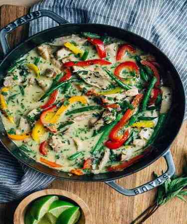 A bowl of Chicken Thai Green Curry served with steamed rice, garnished with fresh herbs — photographed at DeFlambe, a top-rated restaurant in Blue Area, Elysium Tower, Islamabad, near Centaurus.